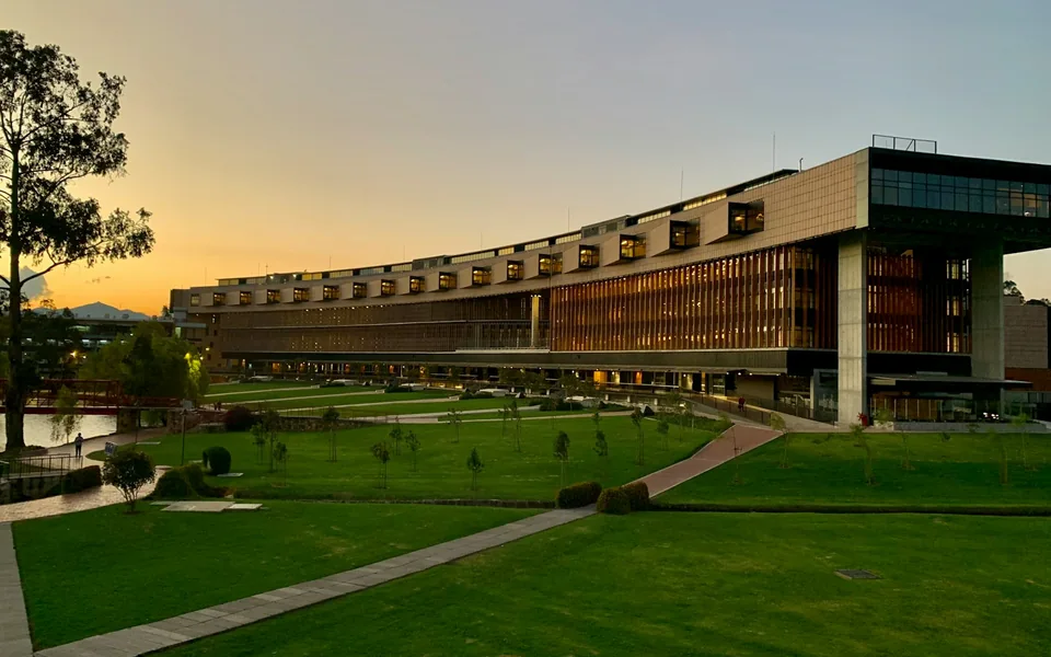 University campus building overlooking a lawn at sunset.