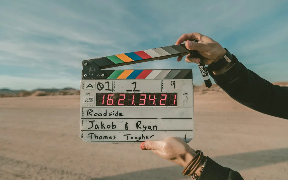 Film clapperboard held on an outdoor production location.