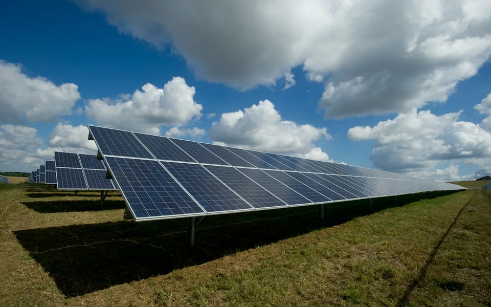 Solar panel arrays installed in a green field.